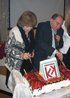 Юрий Раскин и Лидия Поспелова разрезают праздничный торт.